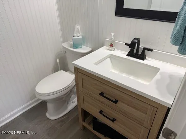 a bathroom with a sink a toilet and mirror