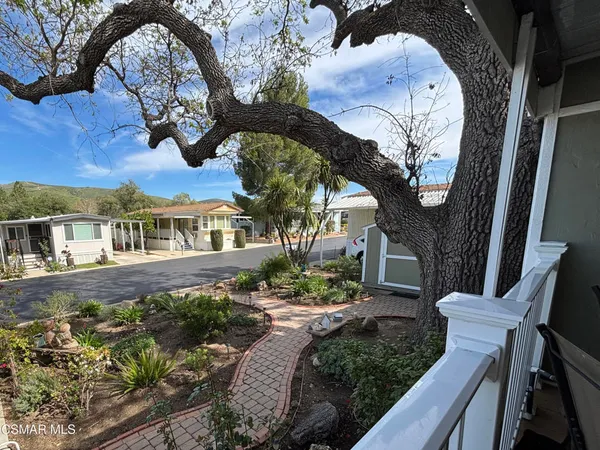 a view of a house with a big yard and large trees