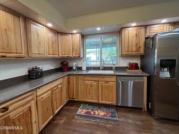 a kitchen with granite countertop a sink window and cabinets
