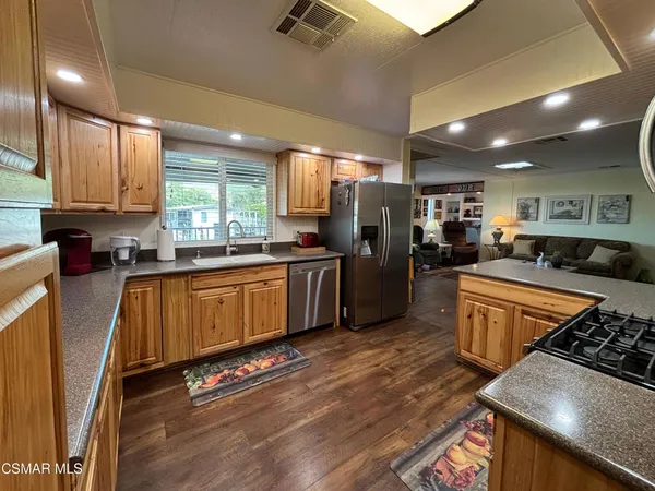 a kitchen with stainless steel appliances a refrigerator sink stove microwave and cabinets