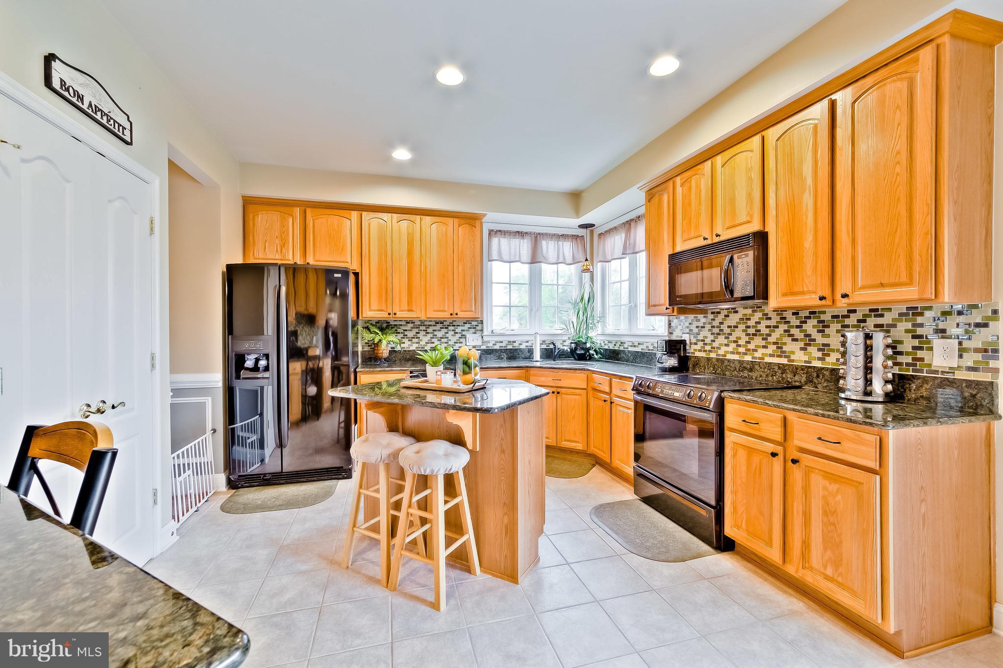 5704 New Forge Road White Marsh, MD 21162 - Photo 11 of 30 a kitchen with stainless steel appliances granite countertop a stove a sink a refrigerator and island