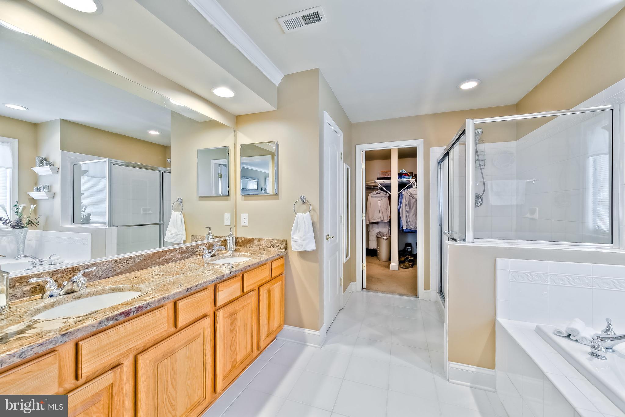 5704 New Forge Road White Marsh, MD 21162 - Photo 23 of 30 a spacious bathroom with a granite countertop sink mirror and a bath tub