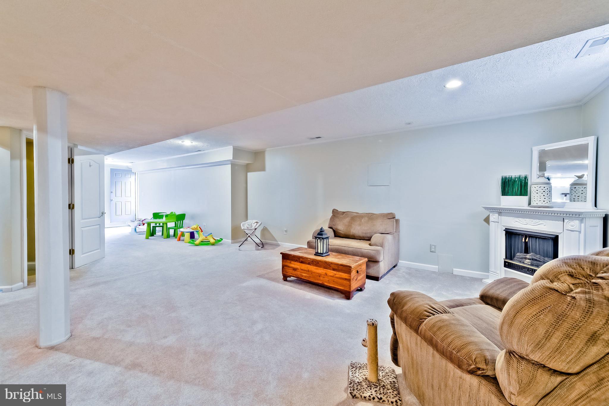 5704 New Forge Road White Marsh, MD 21162 - Photo 26 of 30 a living room with furniture a fireplace and a chandelier