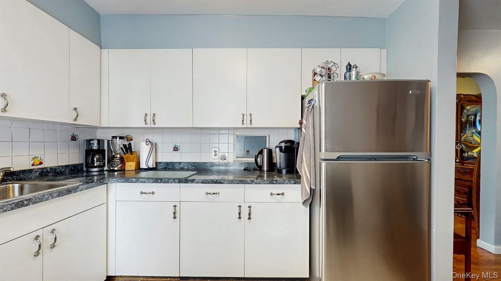 755 Bronx River Road, Unit 6C Bronxville, NY 10708 - Photo 12 of 22 Kitchen with freestanding refrigerator, decorative backsplash, and dark countertops