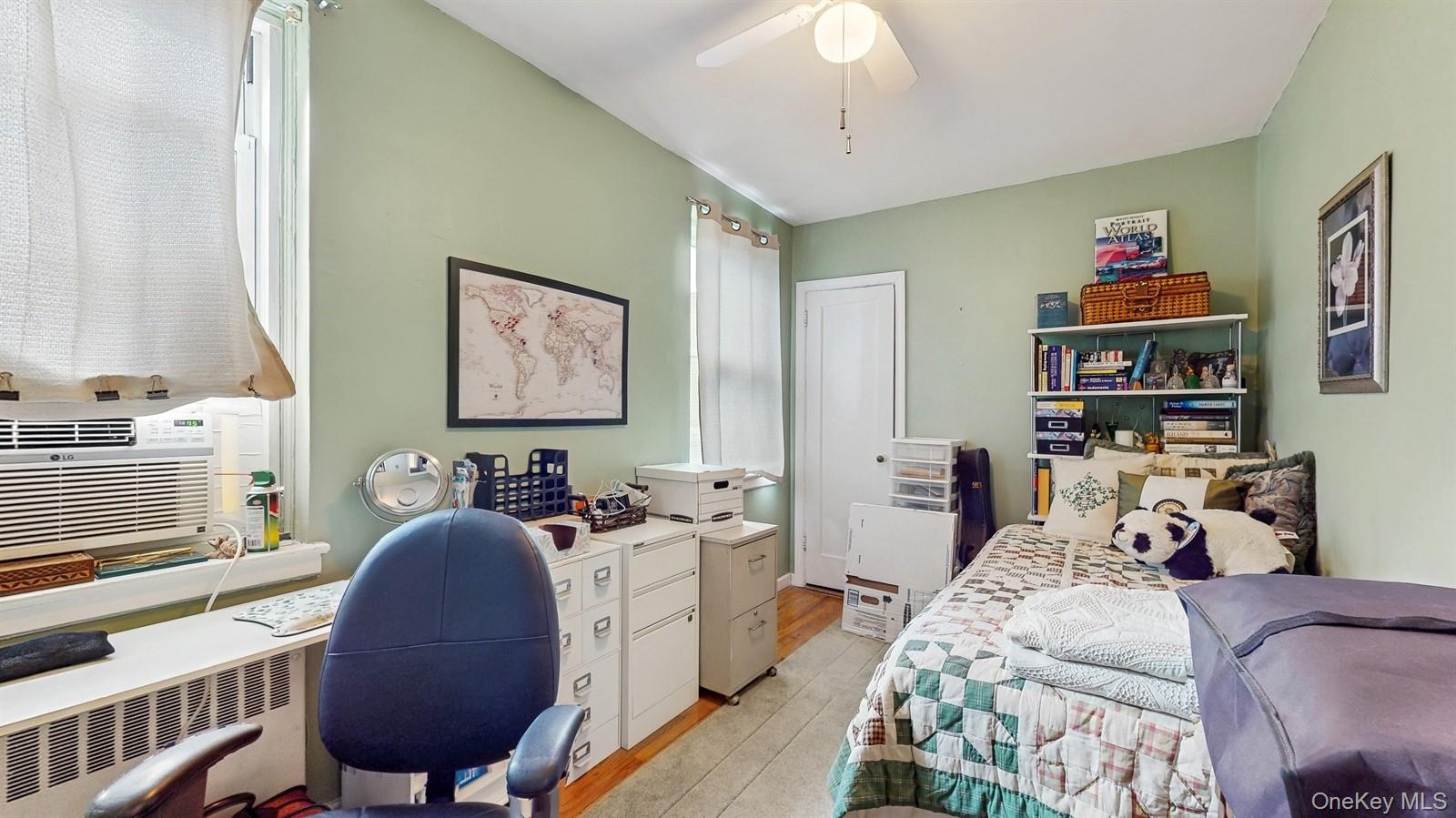 755 Bronx River Road, Unit 6C Bronxville, NY 10708 - Photo 14 of 22 Bedroom featuring light wood finished floors, a desk, radiator heating unit, ceiling fan, and cooling unit