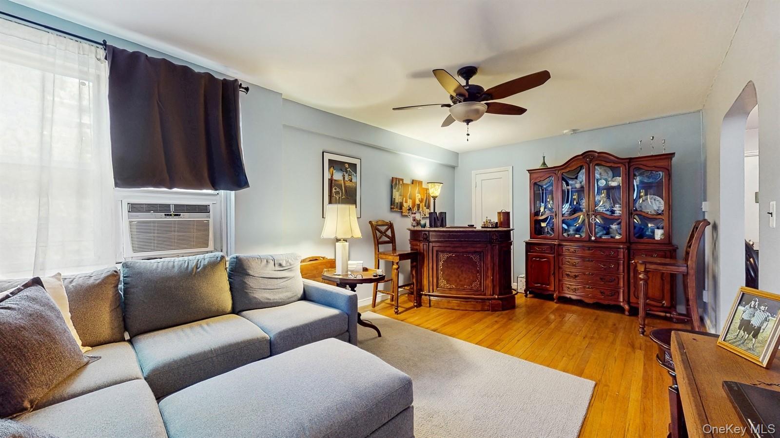 755 Bronx River Road, Unit 6C Bronxville, NY 10708 - Photo 2 of 22 Living room with a ceiling fan, light wood-type flooring, arched walkways, and cooling unit