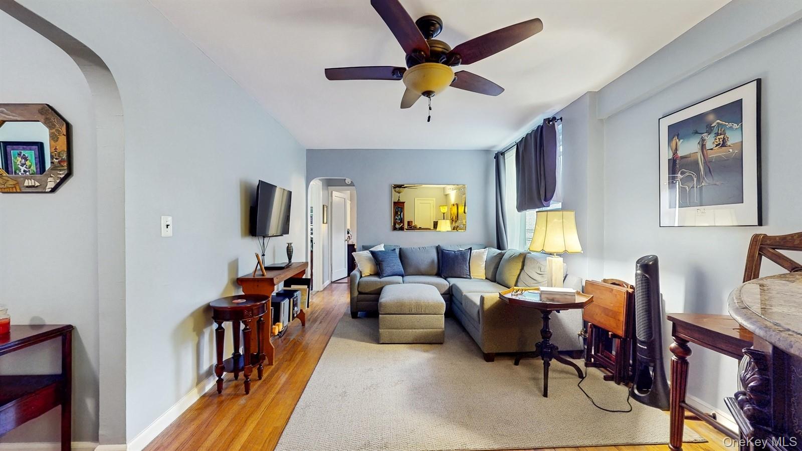755 Bronx River Road, Unit 6C Bronxville, NY 10708 - Photo 3 of 22 Living area with arched walkways, light wood-style flooring, and ceiling fan