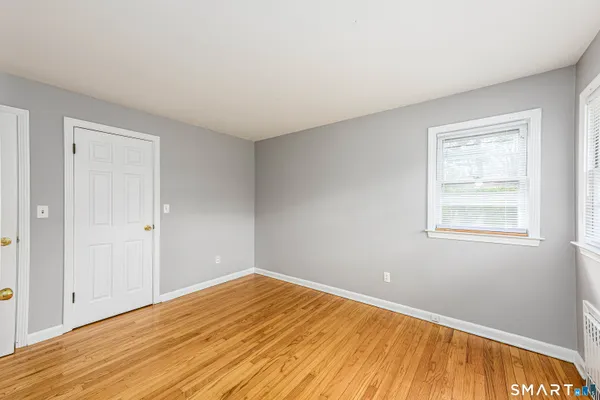 a view of empty room with wooden floor