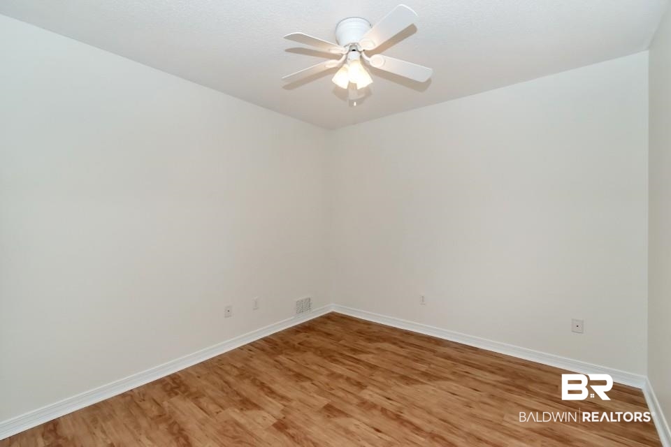 672 Spring Lake Drive East Mobile, AL 36695 - Photo 10 of 26 Spare room featuring baseboards, ceiling fan, and light wood finished floors