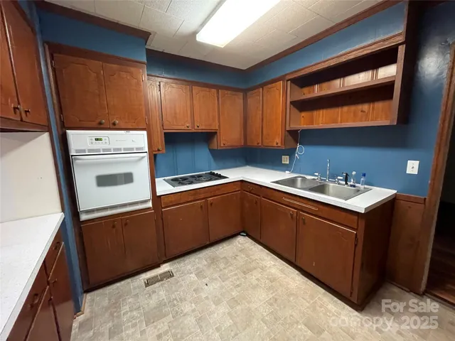 a kitchen with granite countertop a sink stainless steel appliances and cabinets