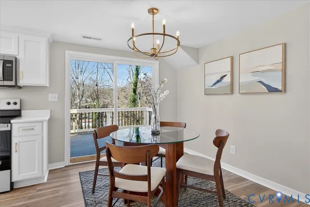 a dining room with furniture a chandelier and wooden floor