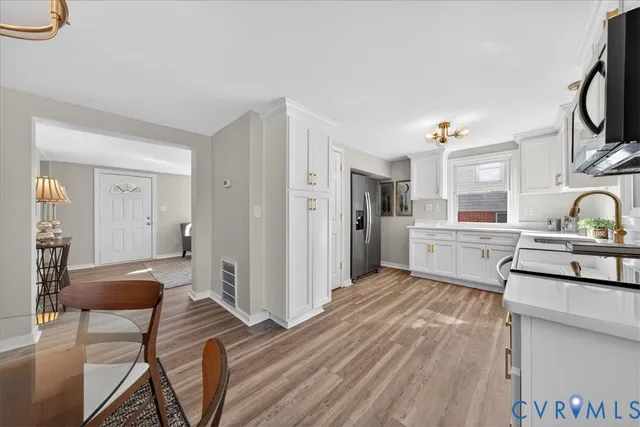 a kitchen with white cabinets and appliances