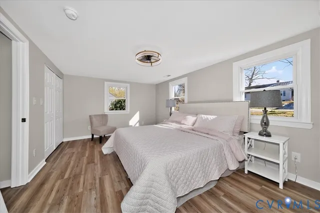 a spacious bedroom with a bed and wooden floor