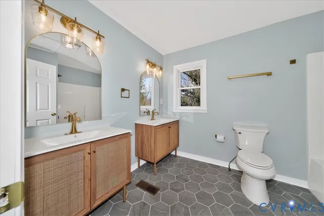 a spacious bathroom with a toilet sink and mirror