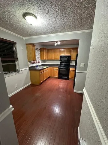 a kitchen with stainless steel appliances wooden floor and a refrigerator