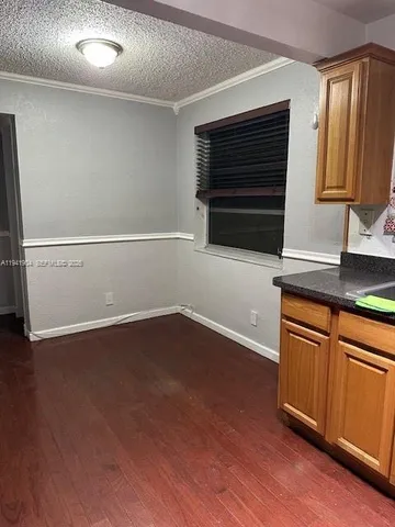 a kitchen with granite countertop wooden cabinets and a wooden floor
