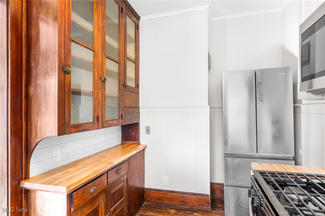 1905 Fulton Road, Unit 2B Cleveland, OH 44113 - Photo 14 of 31 Kitchen with crown molding, appliances with stainless steel finishes, butcher block counters, and dark wood-type flooring