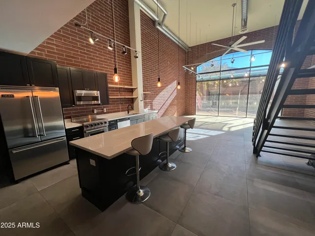 a kitchen with kitchen island granite countertop a sink counter top space and cabinets