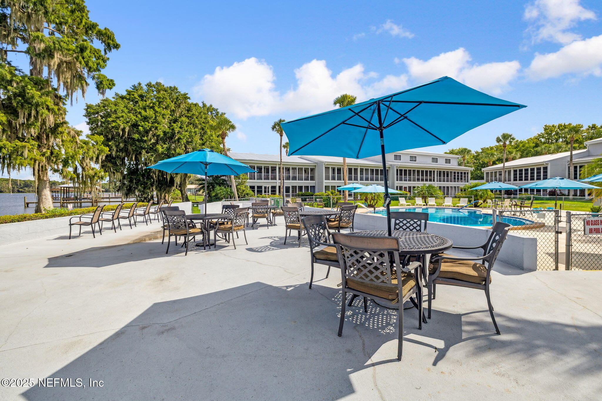 125 River Bend Road, Unit BLD D Welaka, FL 32193 - Photo 39 of 62 a patio with a table and chairs under an umbrella