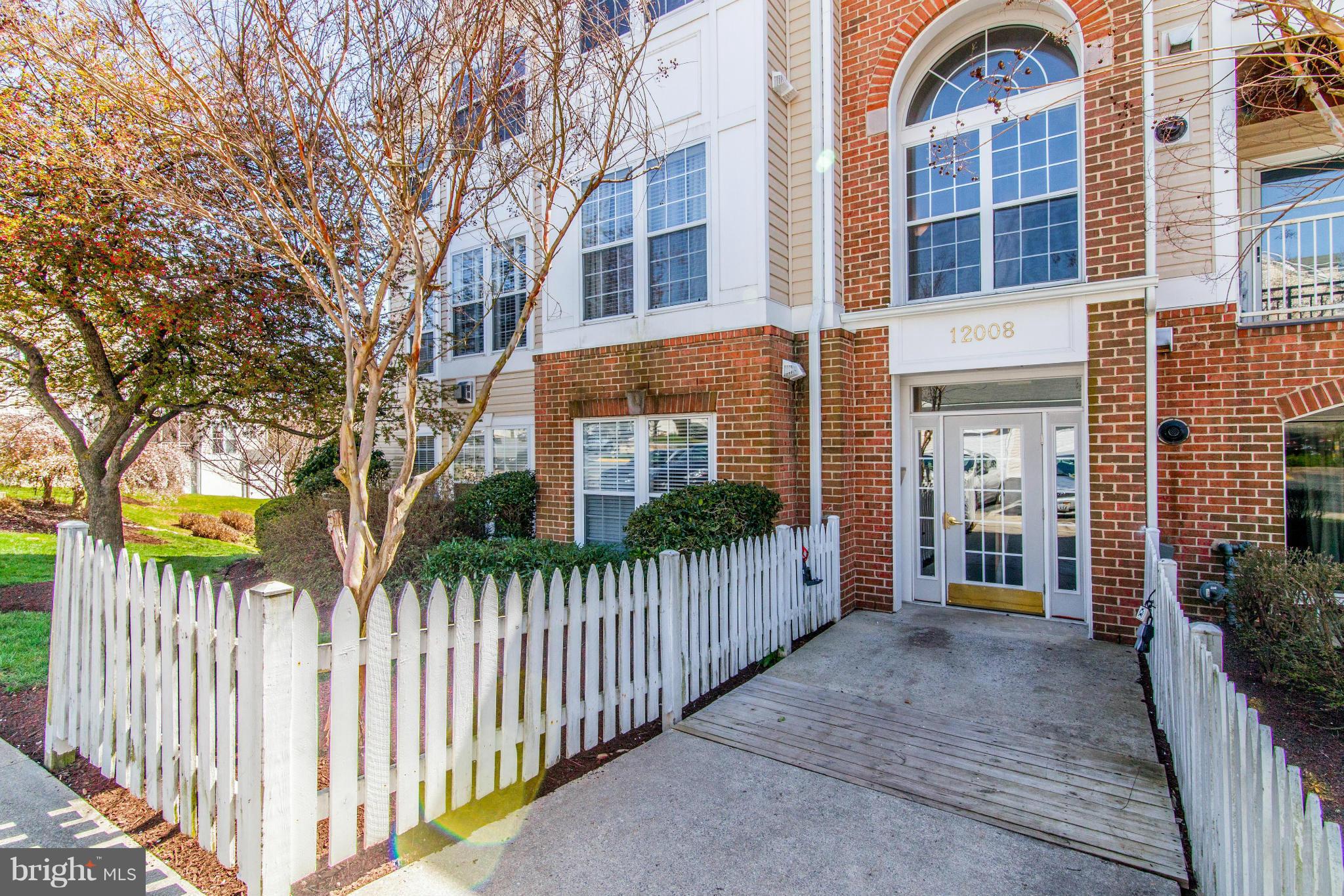 12008 Amber Ridge Circle, Unit A301 Germantown, MD 20876 - Photo 1 of 22 a view of a brick house many windows and a large tree