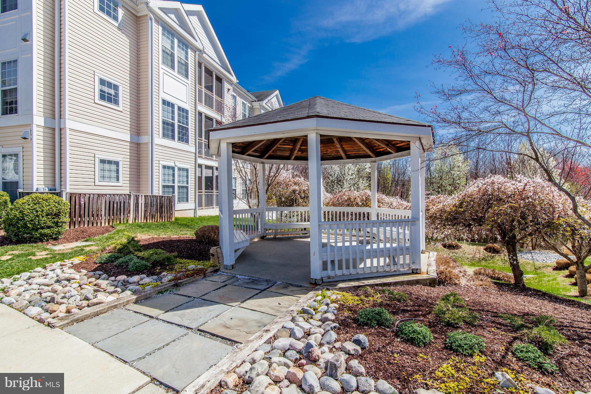12008 Amber Ridge Circle, Unit A301 Germantown, MD 20876 - Photo 22 of 22 a front view of a house with a garden
