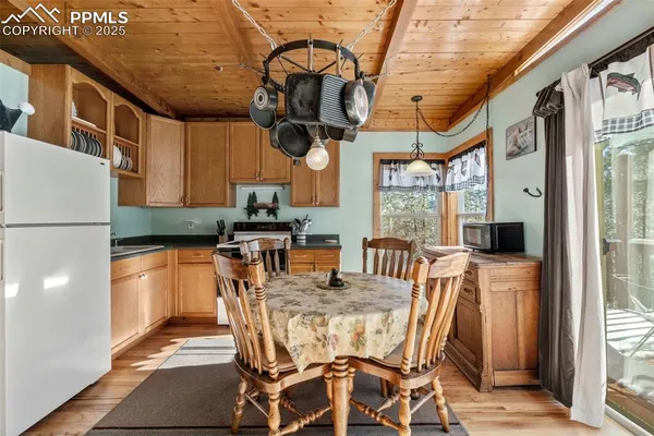 a dining room with stainless steel appliances granite countertop furniture and a refrigerator