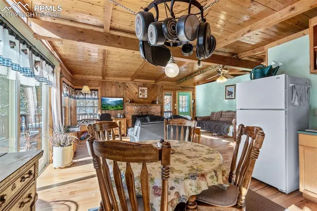 a view of a dining room with furniture a chandelier and kitchen view