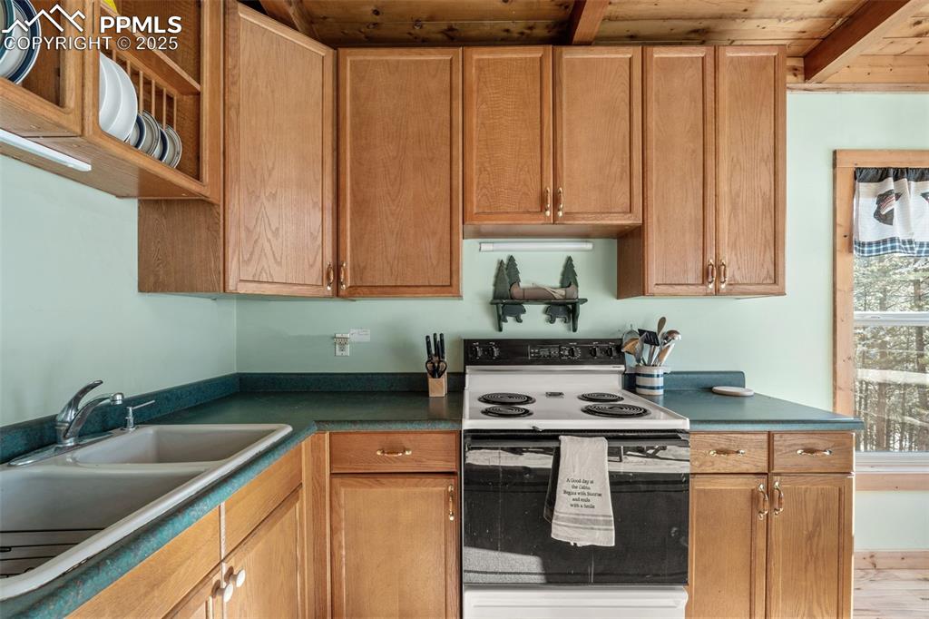 15103 Rainbow Road Sedalia, CO 80135 - Photo 16 of 48 a kitchen with stainless steel appliances granite countertop a sink stove and cabinets