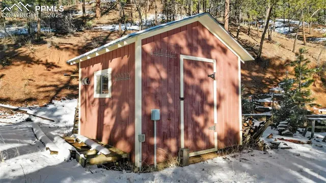a view of a wooden house with a small yard and large tree
