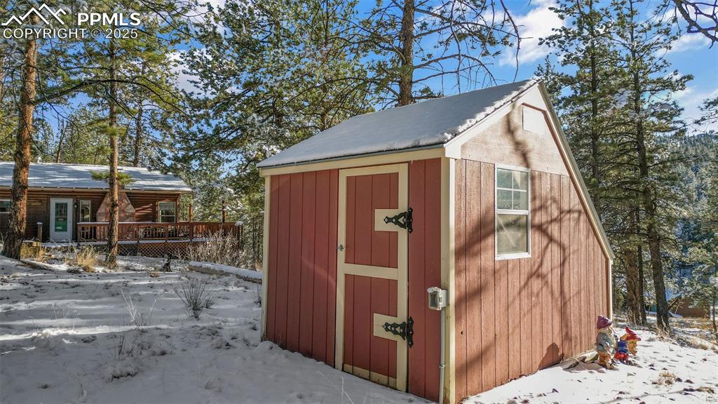 15103 Rainbow Road Sedalia, CO 80135 - Photo 33 of 48 a view of a wooden house with a small yard and large tree