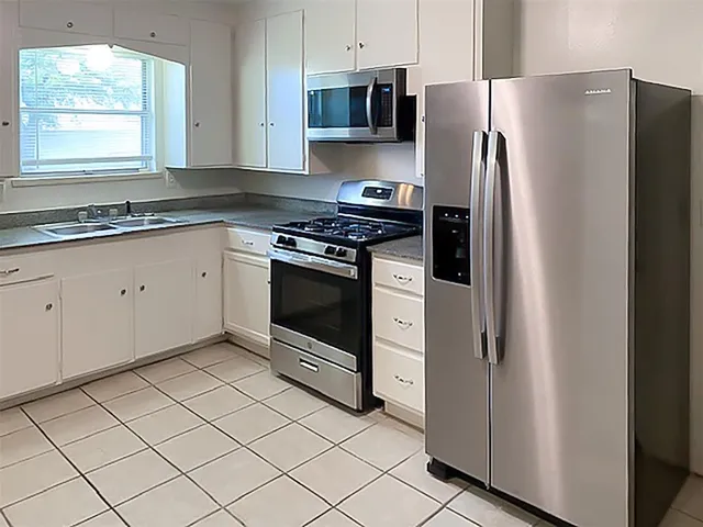 a kitchen with stainless steel appliances granite countertop a refrigerator and a stove