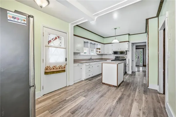 a kitchen with a refrigerator a stove top oven and wooden floor