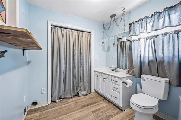 a bathroom with a granite countertop a toilet a sink and a mirror