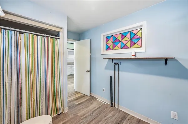 a view of a hallway with wooden floor and closet