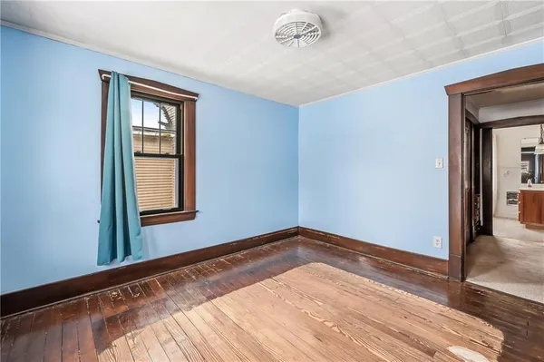 a view of a room with wooden floor and a window