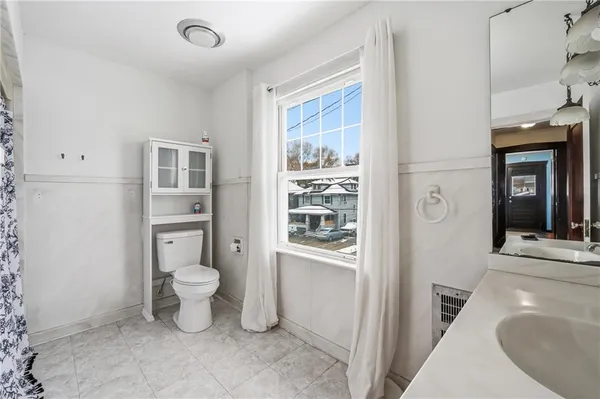 a spacious bathroom with a toilet sink and a mirror
