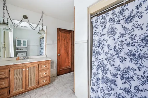 a bathroom with a sink a mirror and a shower curtain