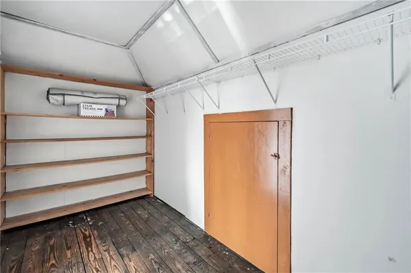 a view of a closet area with wooden floor