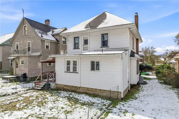 a view of a white house next to a yard