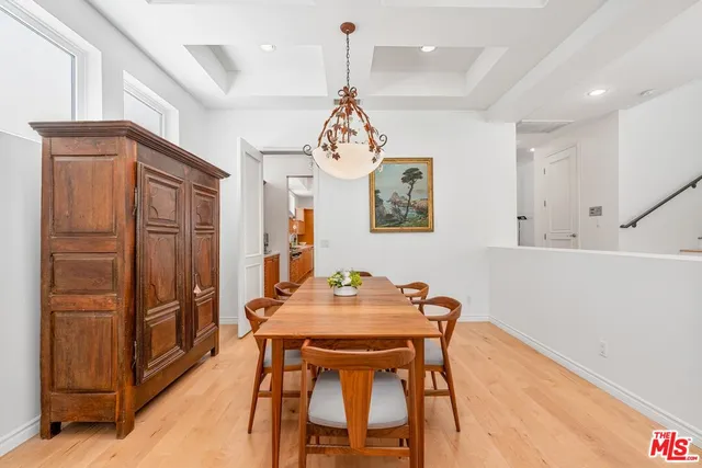 a dining room with stainless steel appliances kitchen island granite countertop furniture and a refrigerator