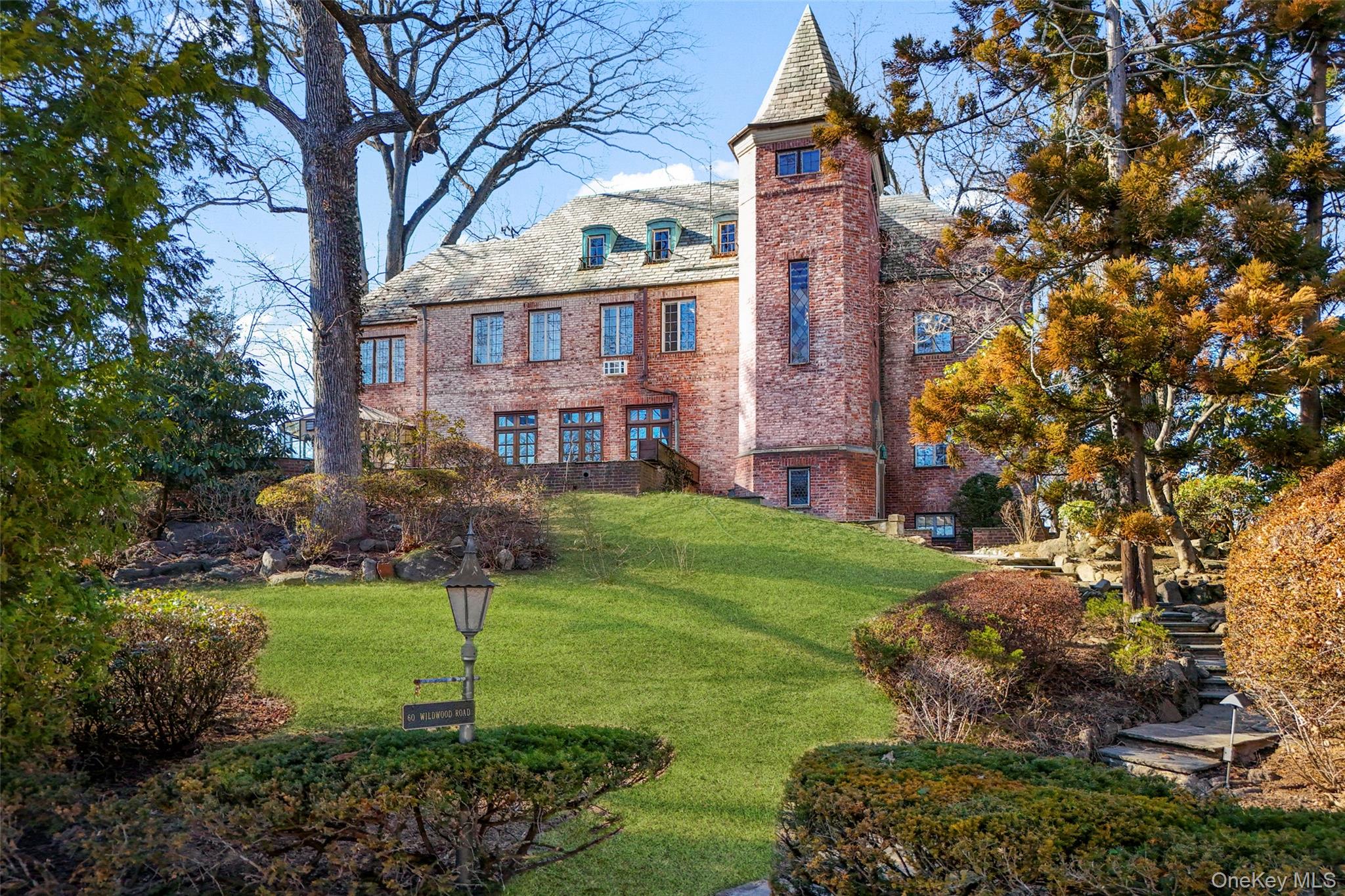 a brick building with a big yard and large trees