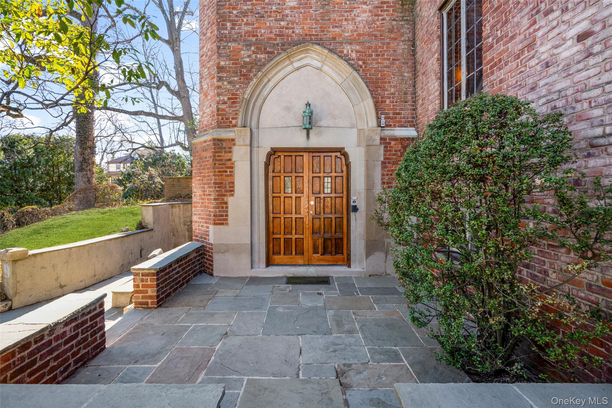 60 Wildwood Road New Rochelle, NY 10804 - Photo 3 of 49 a view of a brick house with a large windows and a flower garden