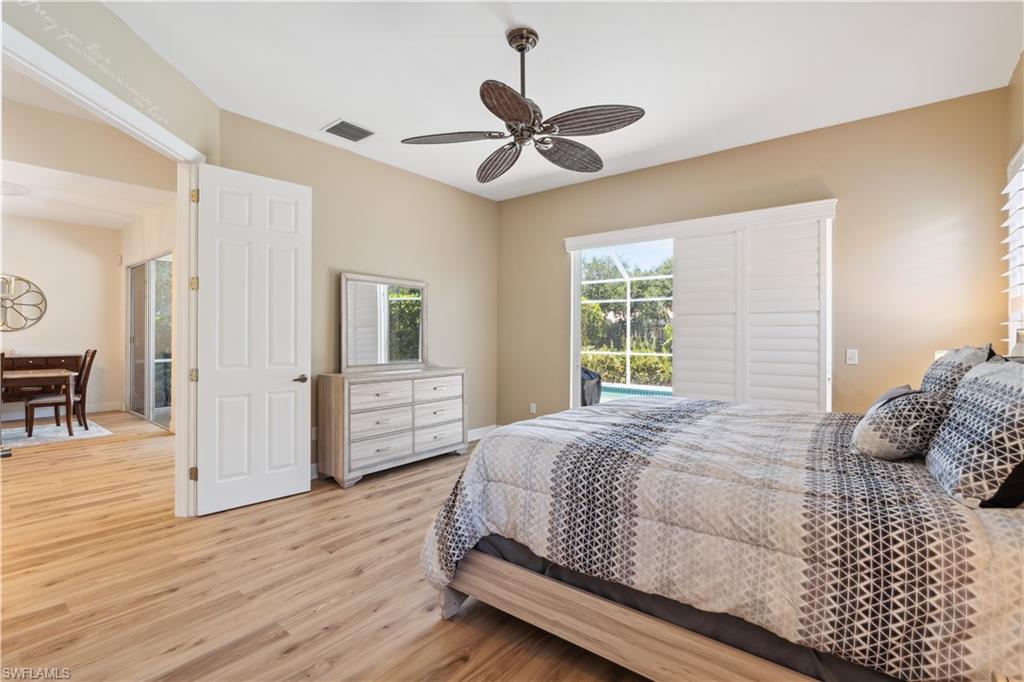 5049 Fairhaven Lane Naples, FL 34109 - Photo 15 of 46 a bedroom with a bed and a chandelier