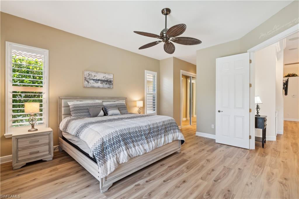 5049 Fairhaven Lane Naples, FL 34109 - Photo 16 of 46 a bedroom with a large bed chandelier and a window