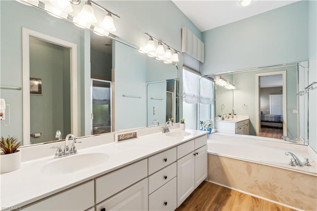5049 Fairhaven Lane Naples, FL 34109 - Photo 17 of 46 a bathroom with double vanity sinks and a large mirror