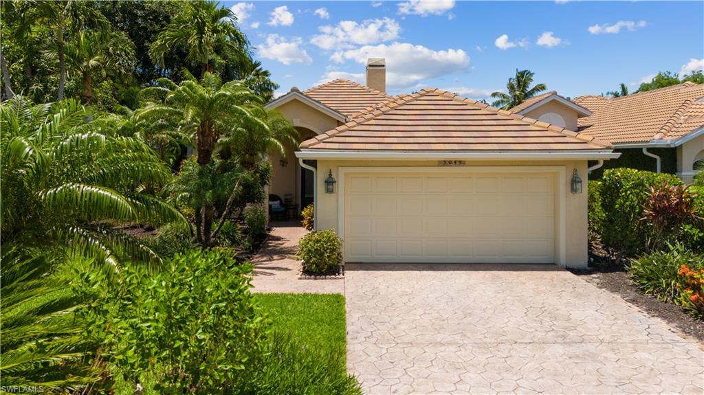 5049 Fairhaven Lane Naples, FL 34109 - Photo 6 of 46 a front view of a house with garden