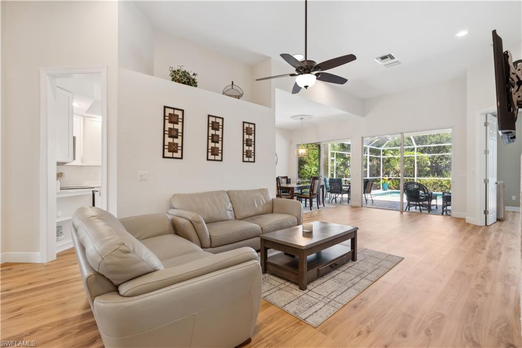 5049 Fairhaven Lane Naples, FL 34109 - Photo 9 of 46 a living room with furniture a ceiling fan and a large window