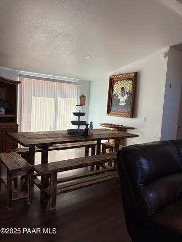 a kitchen with stainless steel appliances granite countertop a stove top oven a dining table and chairs with wooden floor