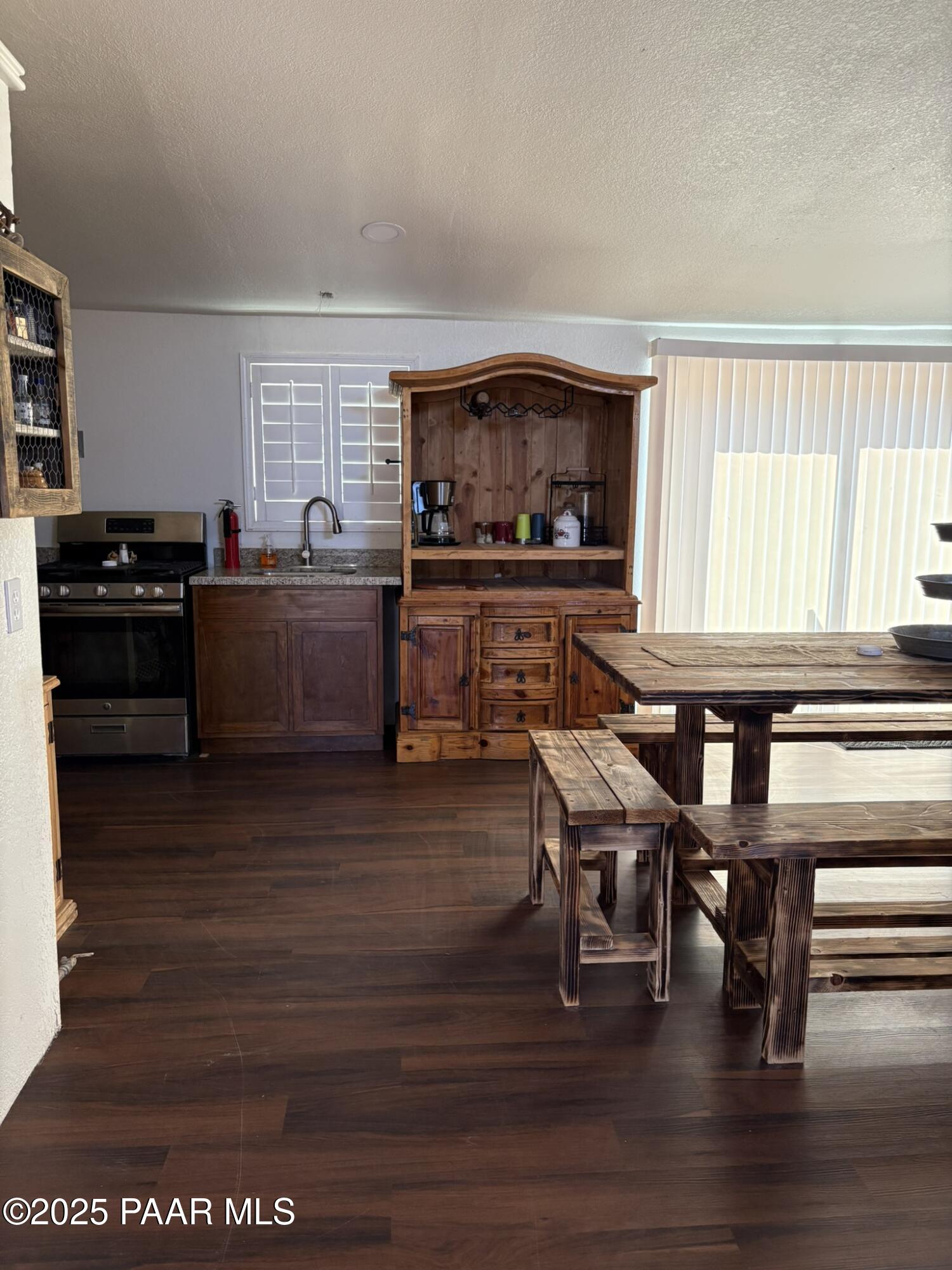 42650 North Wayne Road Ash Fork, AZ 86320 - Photo 29 of 37 a kitchen with stainless steel appliances granite countertop a stove top oven a dining table and chairs with wooden floor