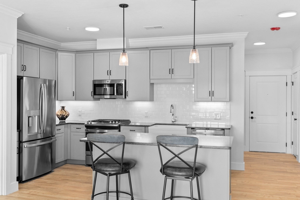 57 Long Point Road, Unit 210 Lakeville, MA 02347 - Photo 6 of 27 a kitchen with stainless steel appliances granite countertop a stove a refrigerator and a refrigerator